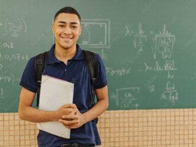 student in front of chalkboard
